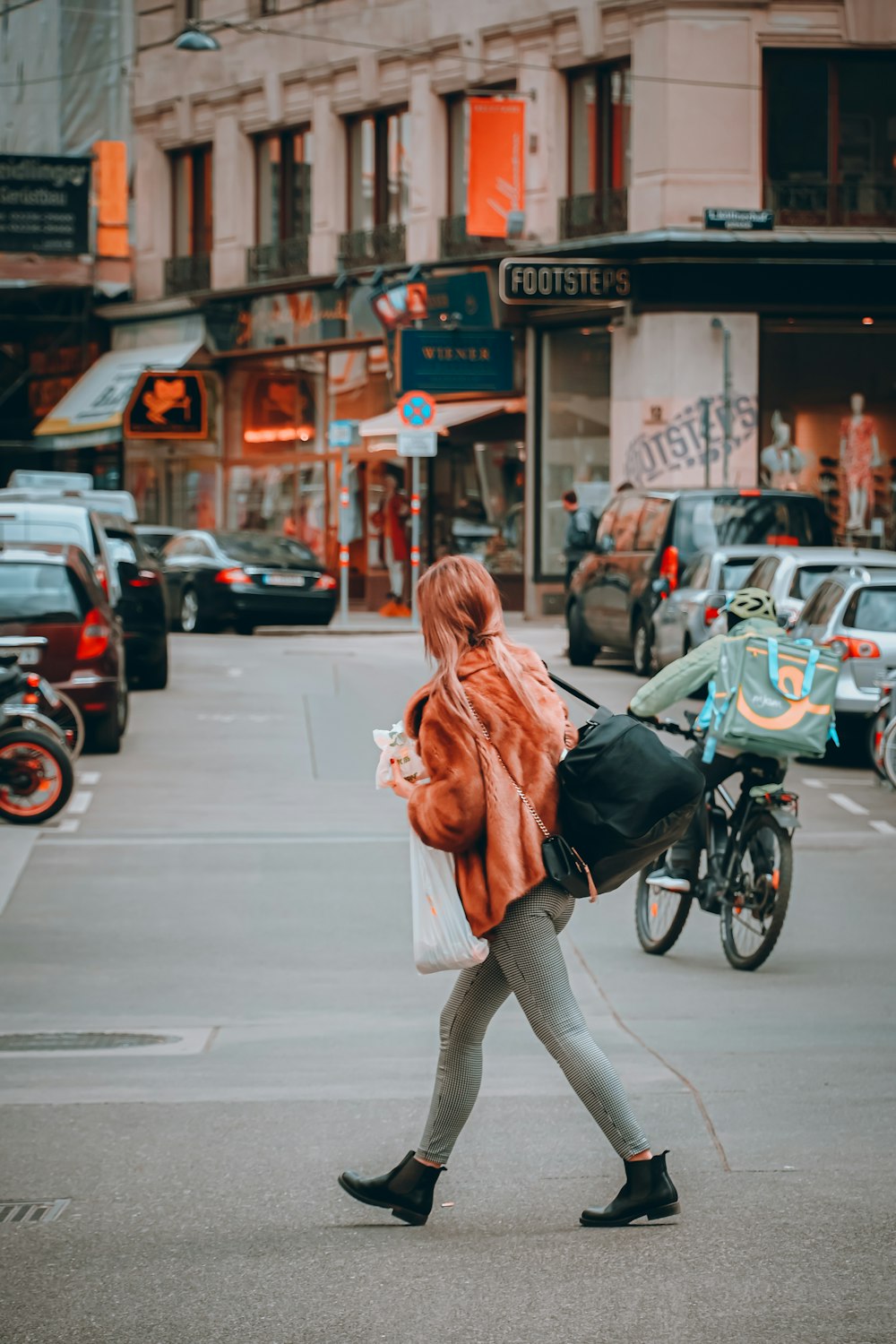 a woman walking down the street carrying a bag