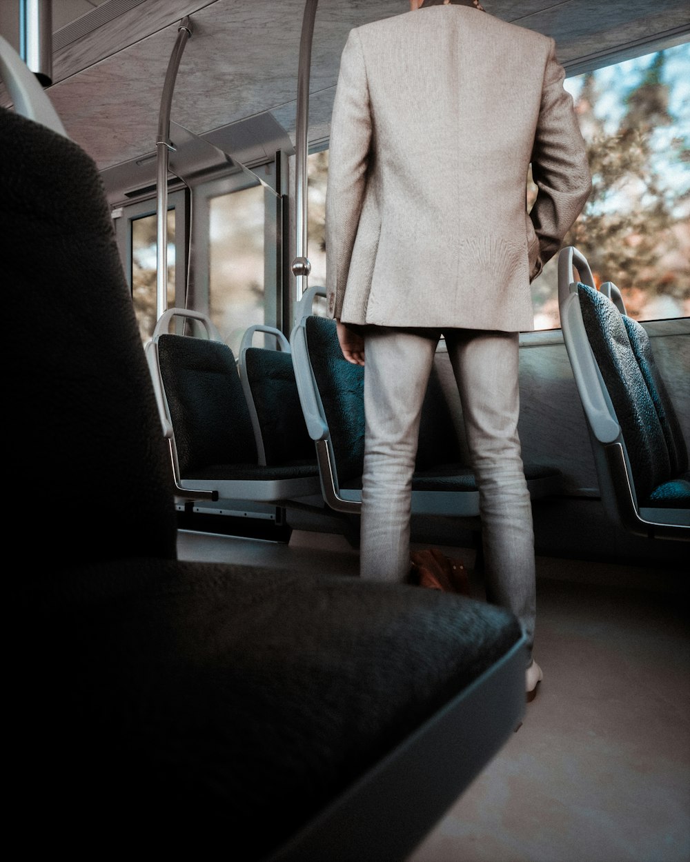 Un uomo in giacca e cravatta in piedi su un autobus