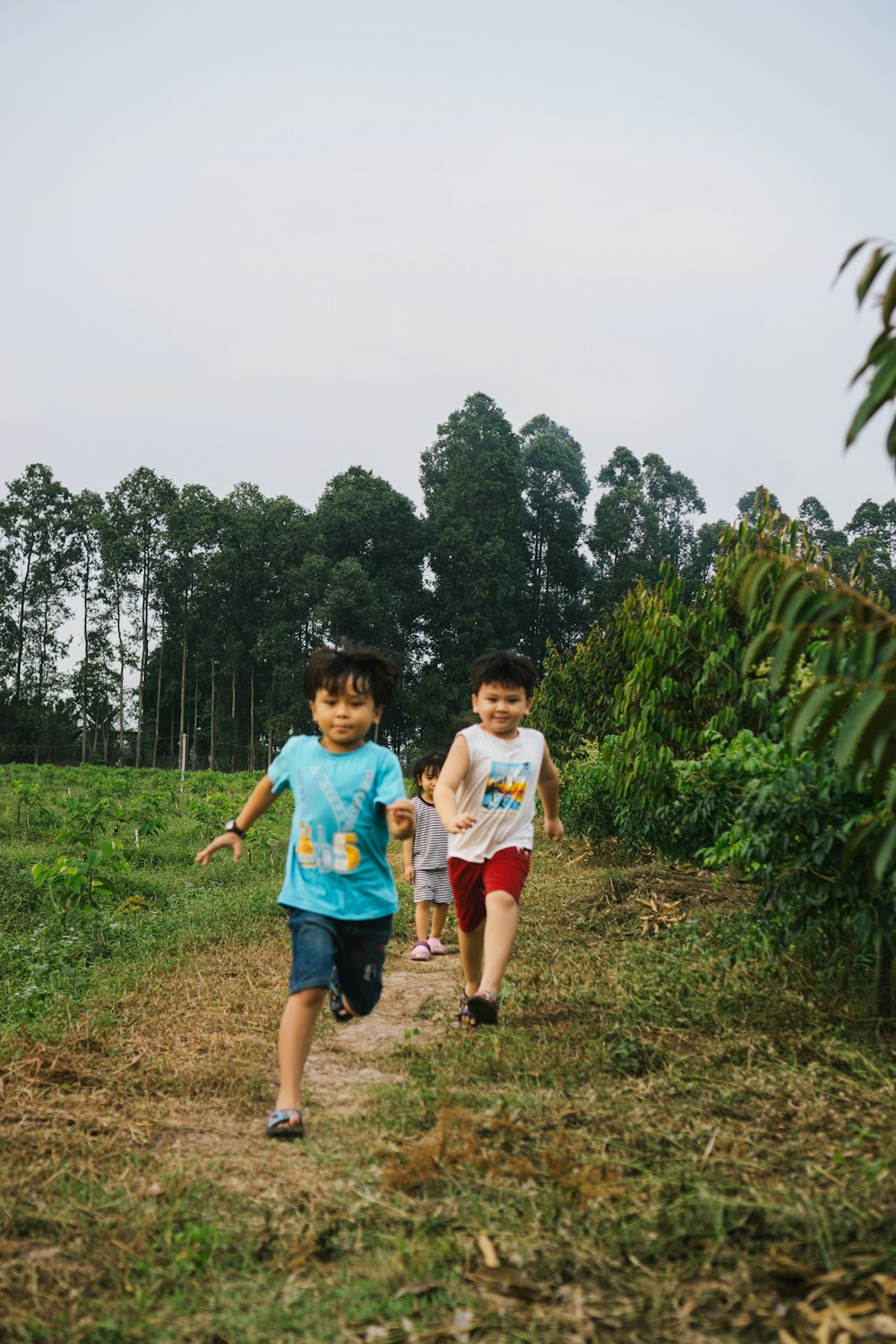 a couple of kids walking down a dirt road