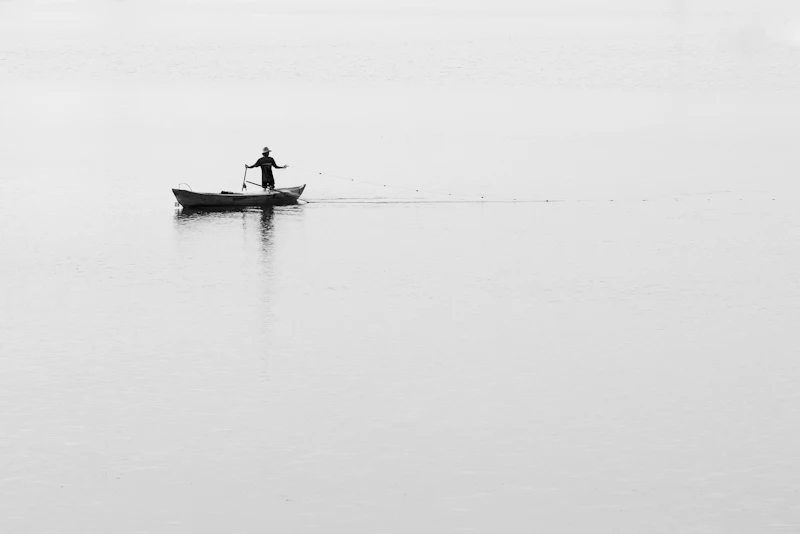 Fischer in einem Holzboot auf einem Nebelsee