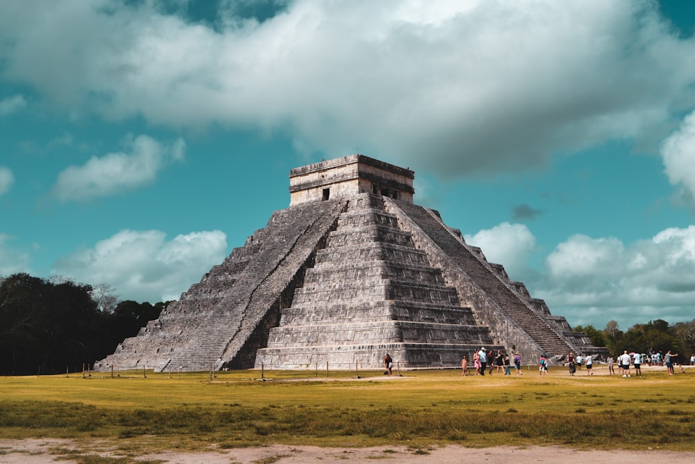 a group of people standing in front of a pyramid