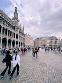 The grand architecture of Brussels’ Grand Place bustling with visitors during a lively festival.