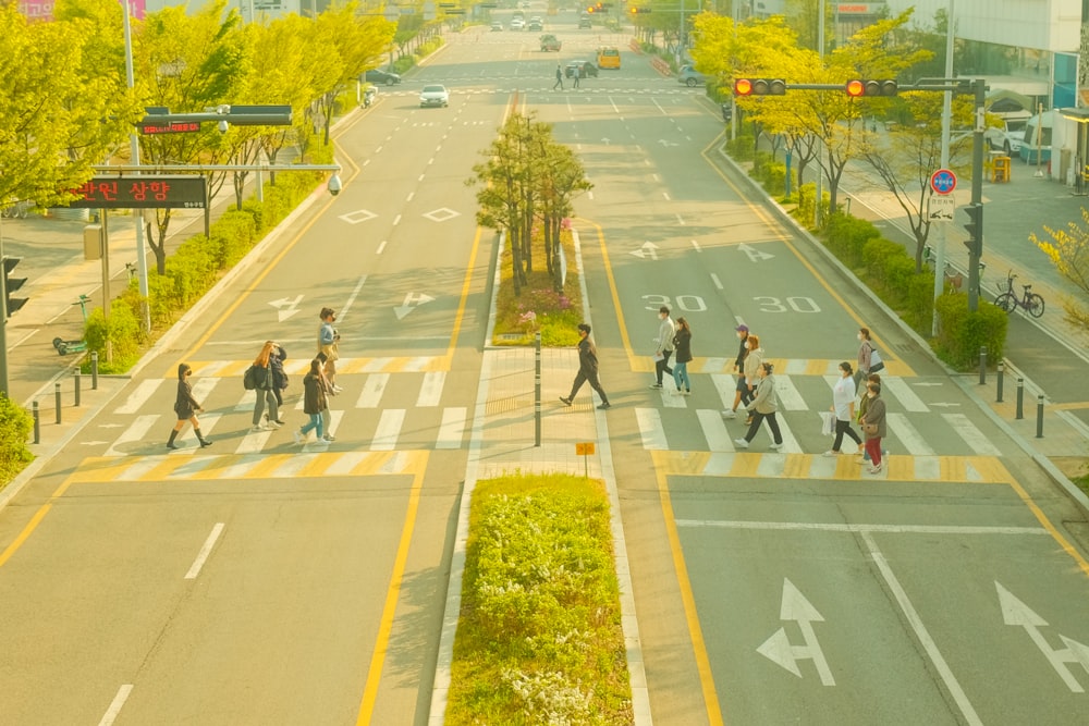 a group of people walking across a street