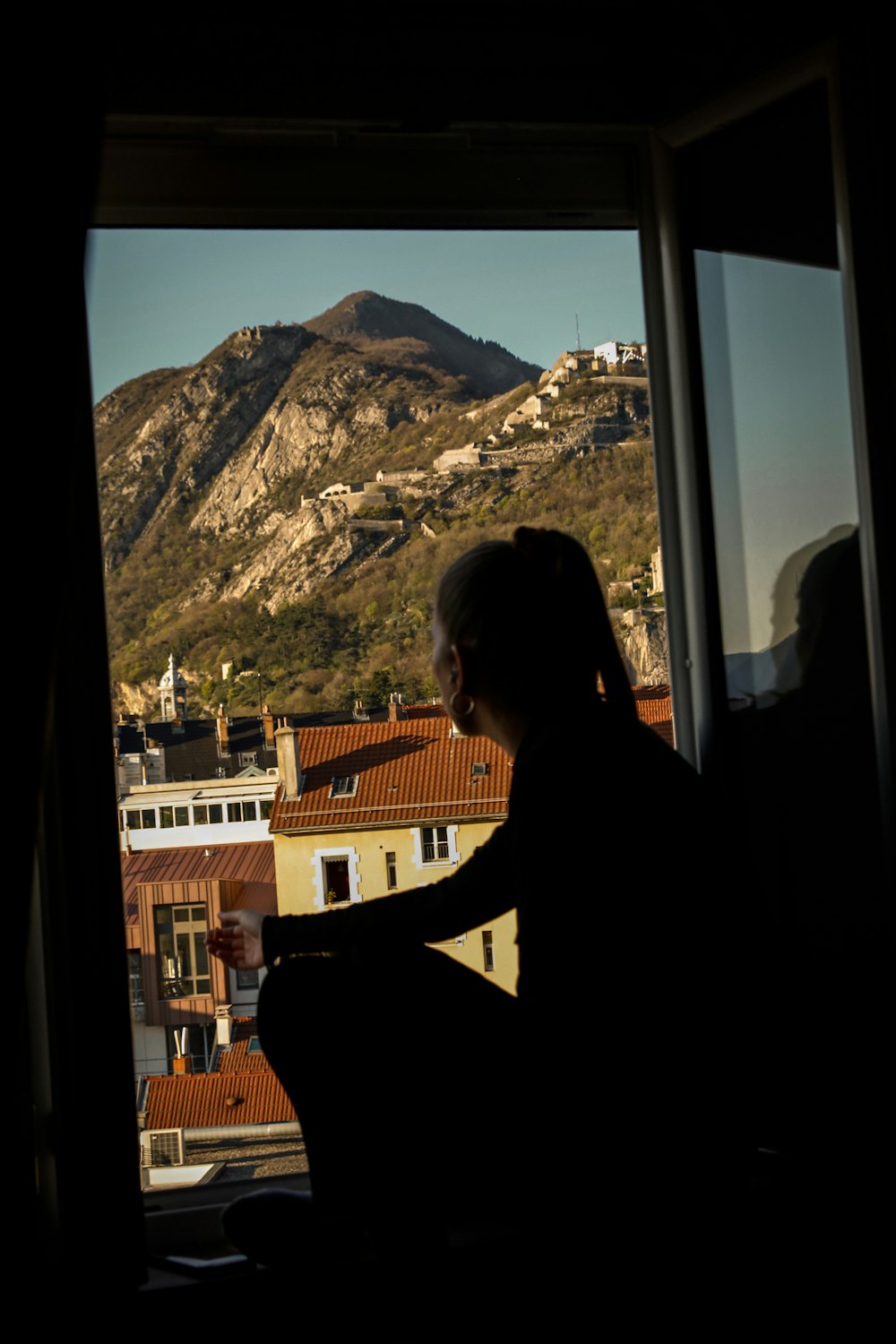 a person sitting in a chair looking out a window