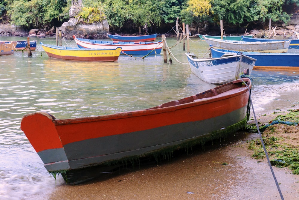 a row boat sitting on top of a sandy beach