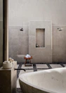 Elegant bathroom featuring smooth stone surfaces and minimalist fixtures with soft charcoal accents.