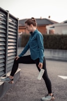 Athlete stretching outdoors wearing b.on high-compression, waist-high leggings.