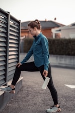 A person stretching outdoors with a bottle of supplements nearby, symbolizing wellness.