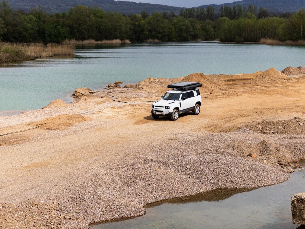 a white truck parked on top of a sandy beach