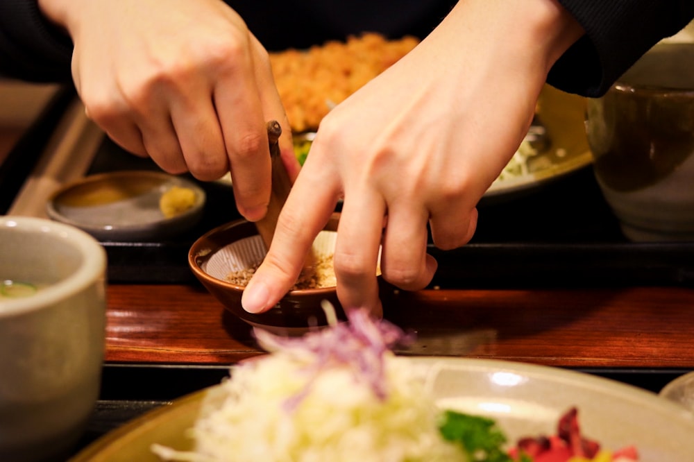 a close up of a person preparing food on a plate