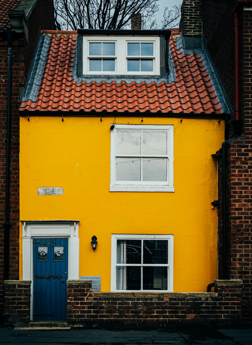 a yellow house with a blue door and window
