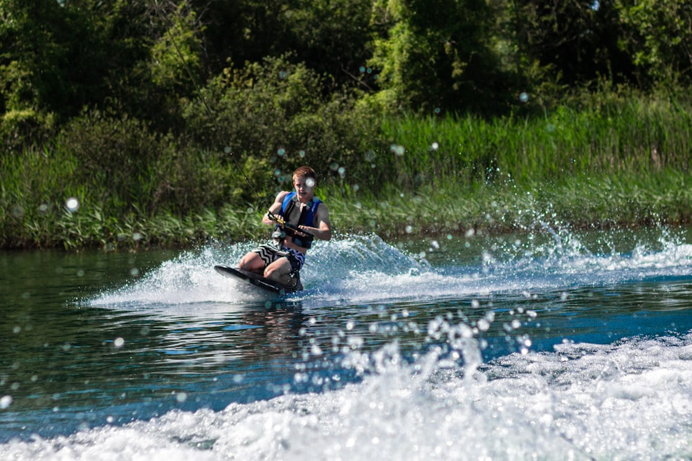 Un hombre montando una moto acuática encima de un cuerpo de agua
