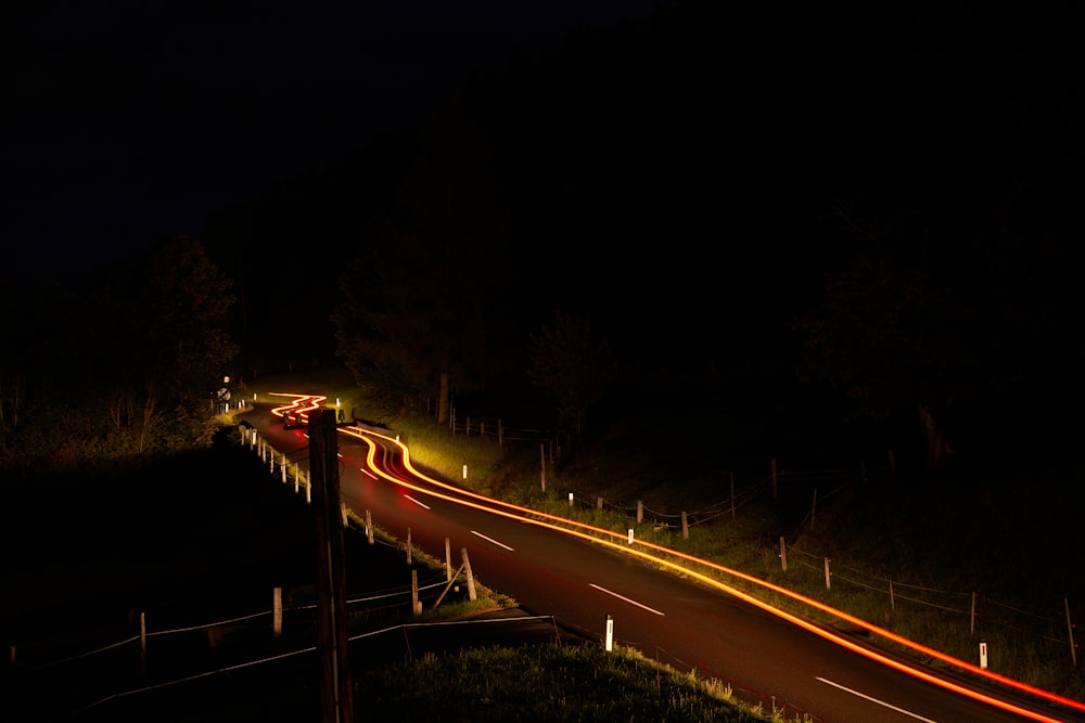 a long exposure photo of a road at night