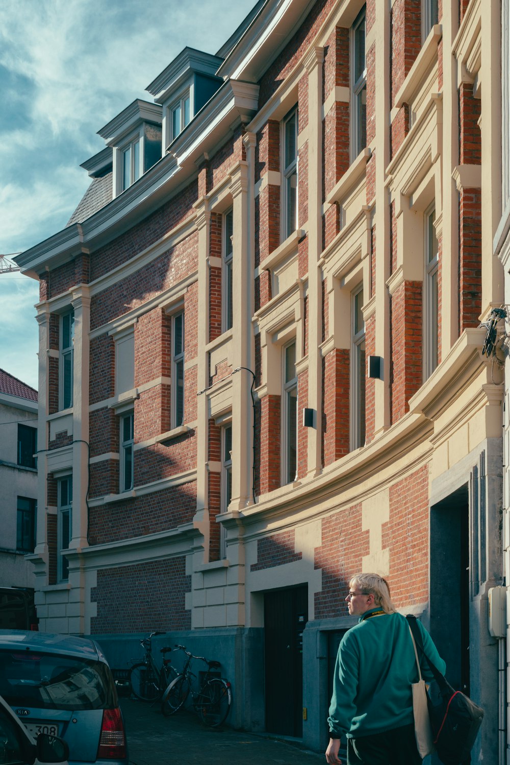 a man walking down a street next to a tall building