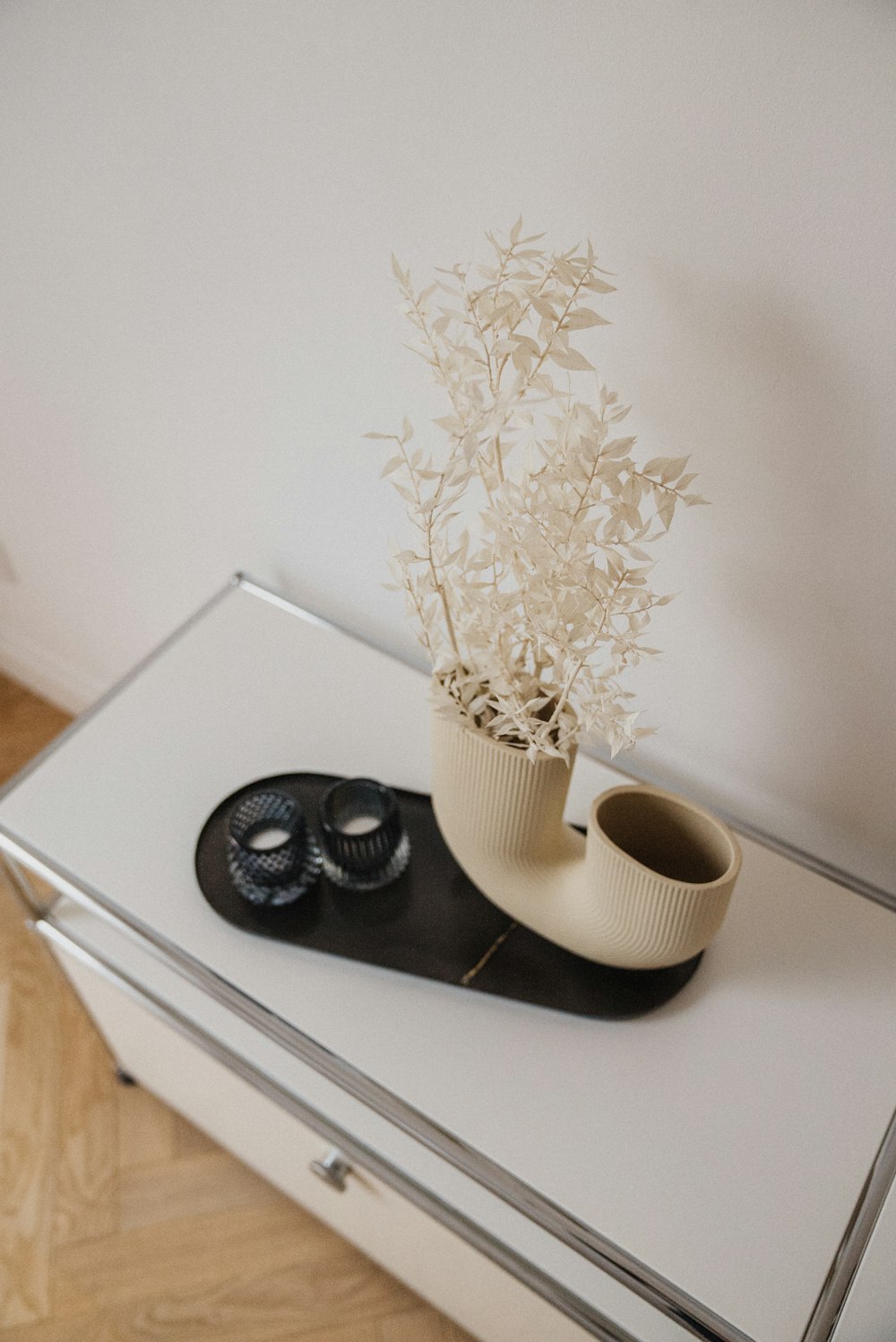 a vase with a plant on top of a table