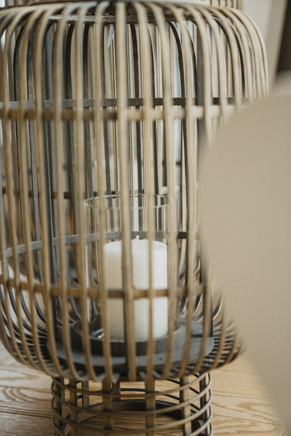 a white candle sitting inside of a bird cage