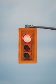 a red traffic light hanging from a metal pole