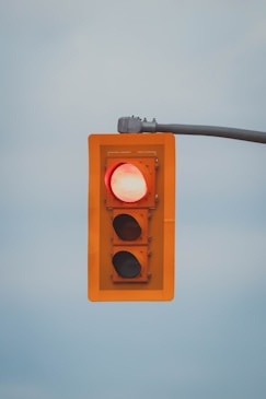 a red traffic light hanging from a metal pole