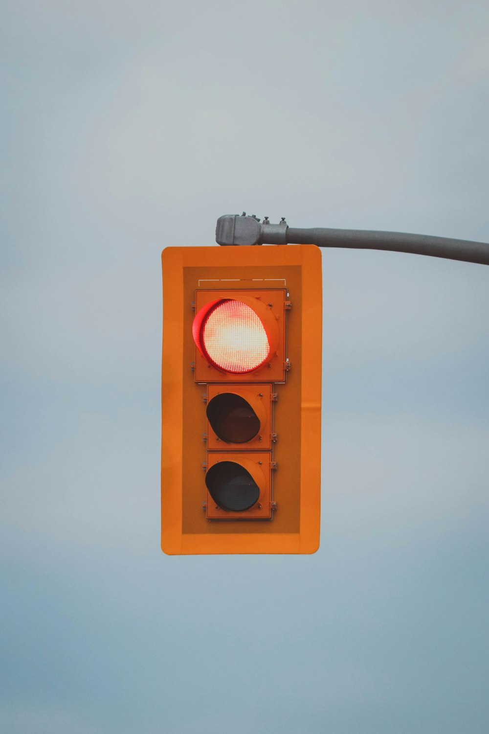 Un semáforo rojo colgando de un poste de metal