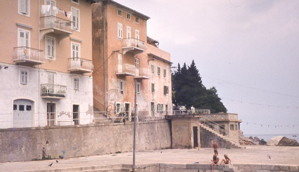 a couple of people sitting on a bench in front of a building