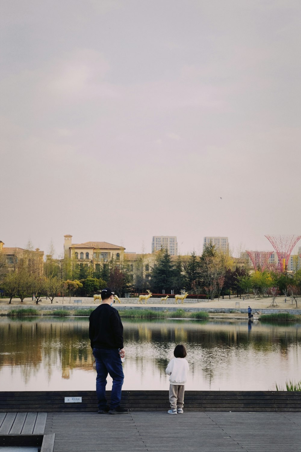 a man and a child are looking at a lake