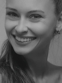 Close-up image of a customer service agent wearing a headset, smiling warmly.