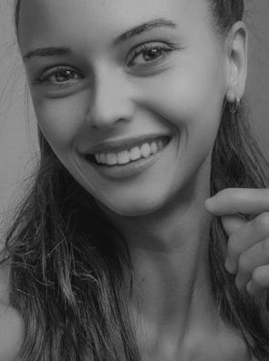 Elegant portrait of a young woman smiling confidently after her smile design treatment.