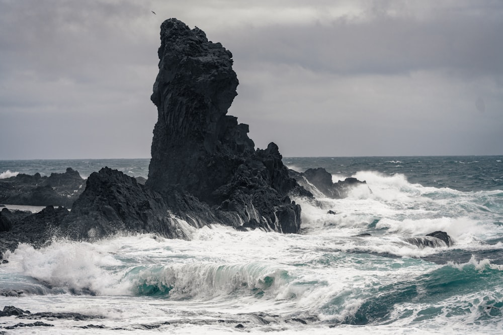 a large rock sticking out of the ocean