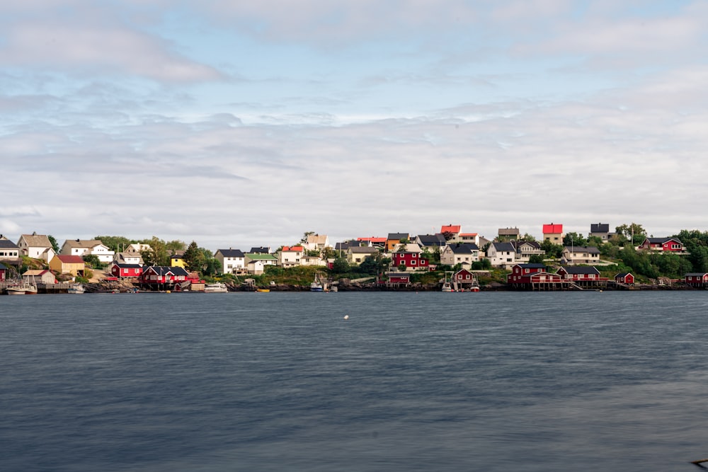 a body of water with houses on a hill in the background