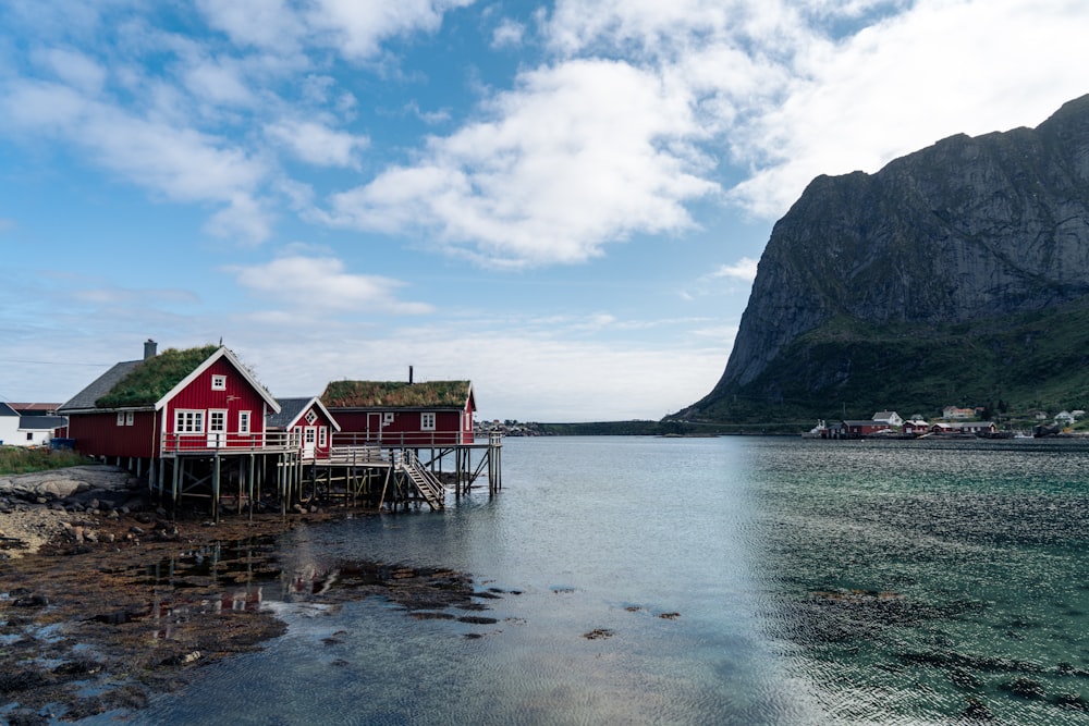 a red house sitting on top of a body of water