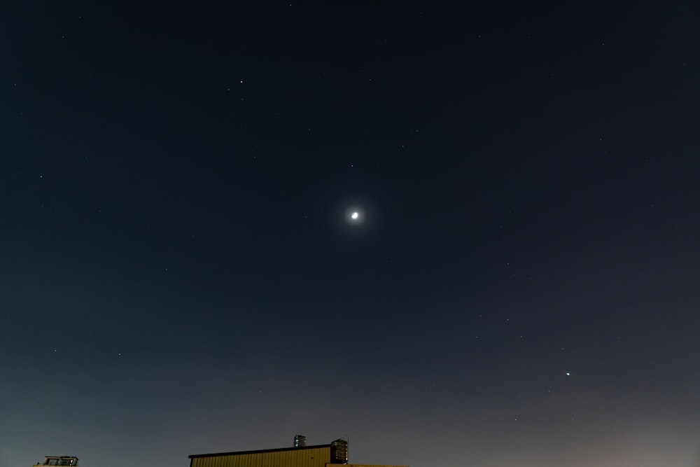 a night sky with the moon and venus in the distance