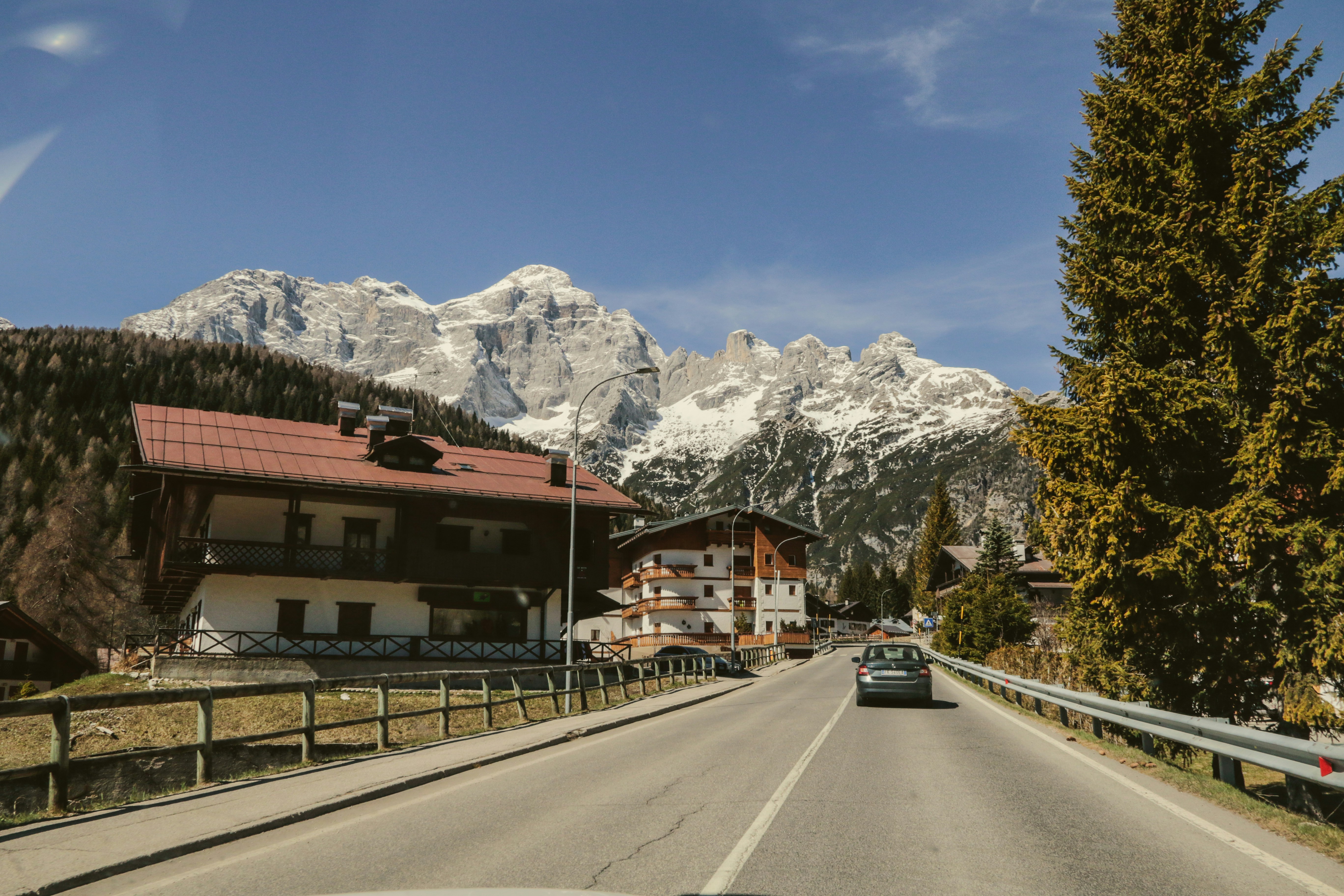 a car driving down a road with mountains in the background