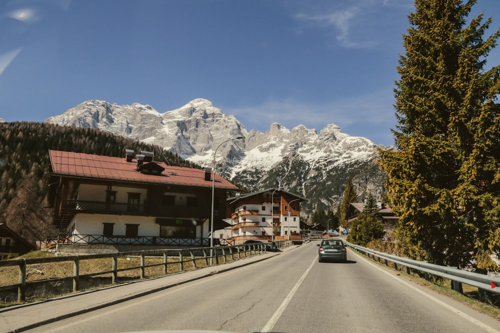 a car driving down a road with mountains in the background