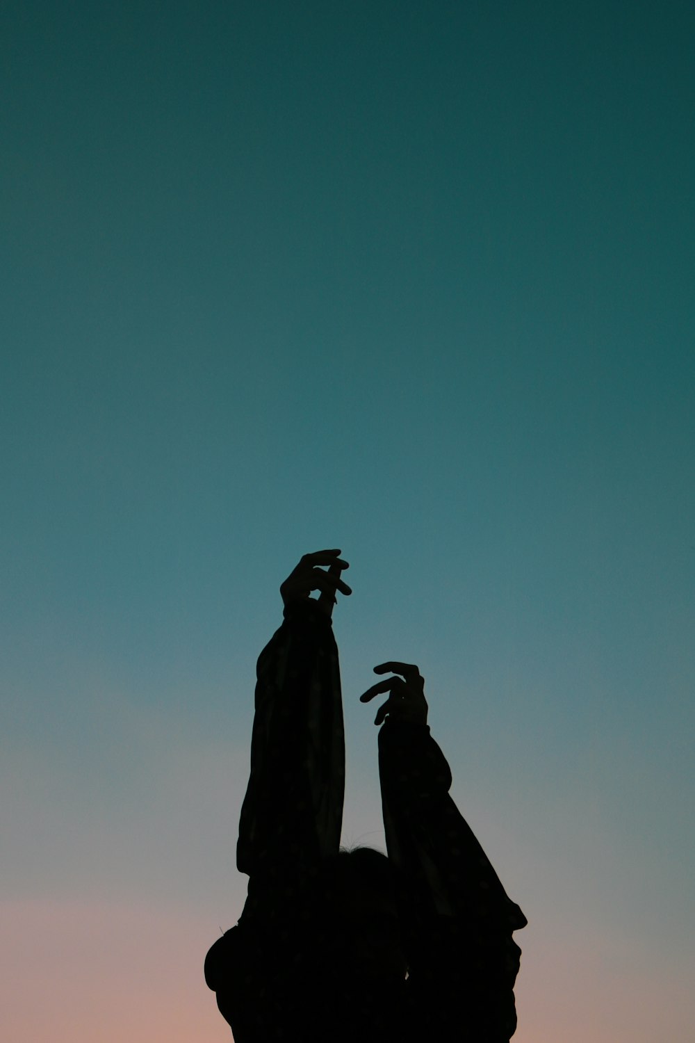 a statue of a person reaching up into the sky