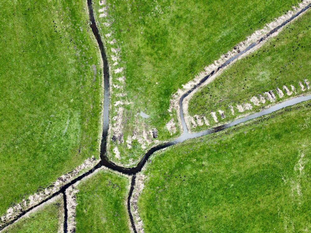 an aerial view of a grassy field with a river running through it
