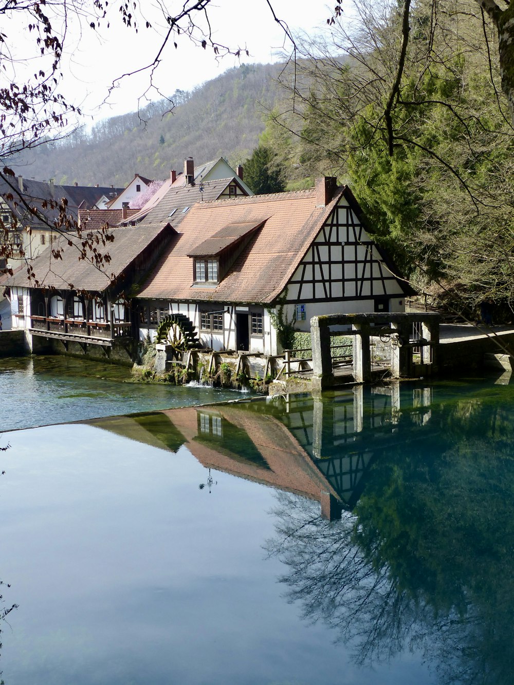 a house on a river with a reflection in the water