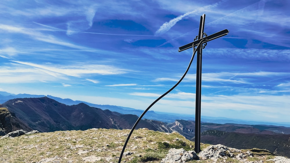 a cross on top of a hill with mountains in the background
