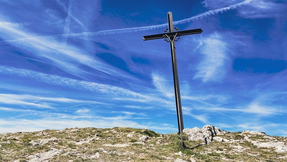 a cross on top of a hill under a blue sky