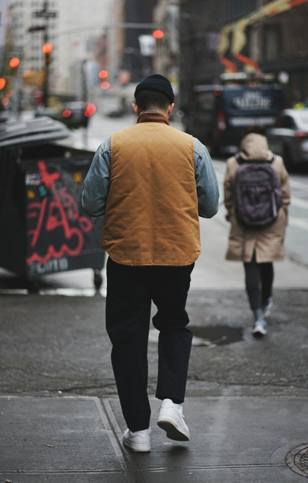a man walking down a street with a backpack