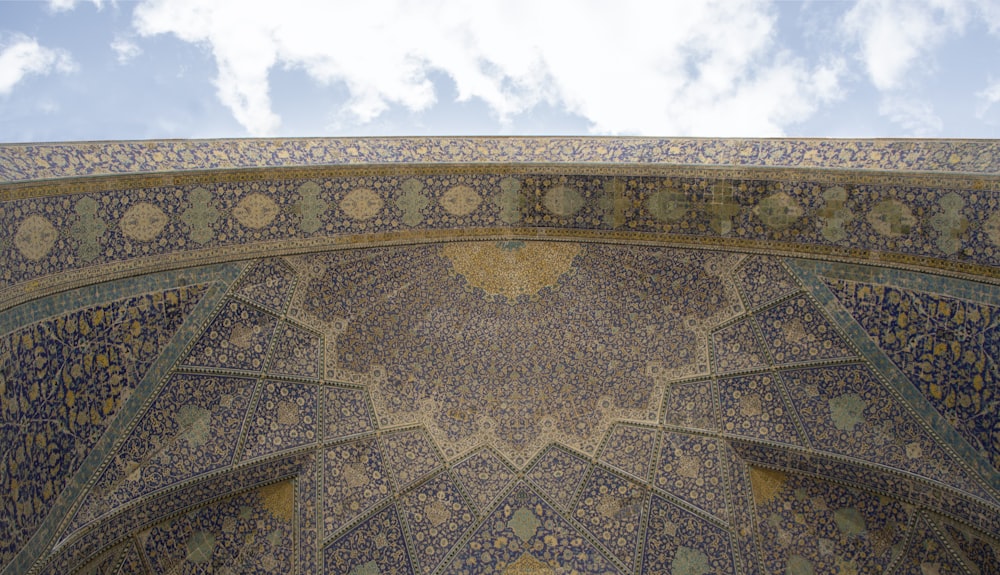 an intricately designed wall with a sky background