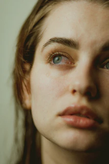 A serene close-up of a person’s thoughtful eyes reflecting soft natural light, embodying calm introspection.