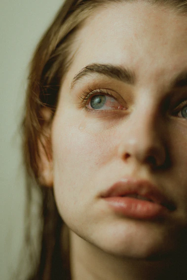 A serene close-up of a person’s thoughtful eyes reflecting soft natural light, embodying calm introspection.