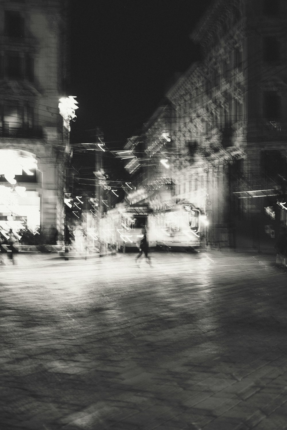 a black and white photo of a city street at night