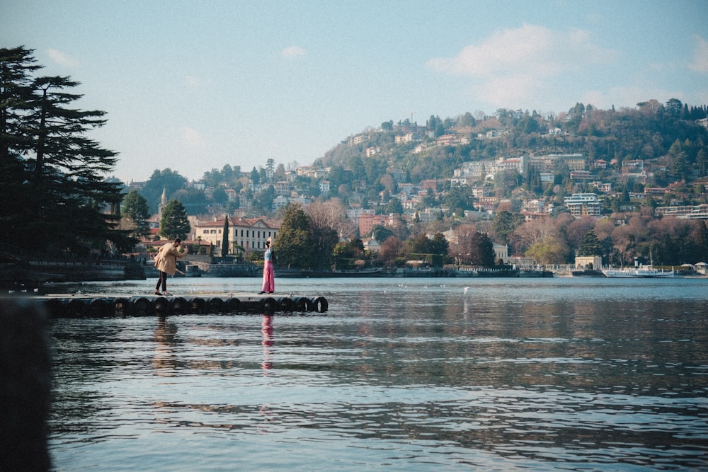 a person standing on a dock in the middle of a lake