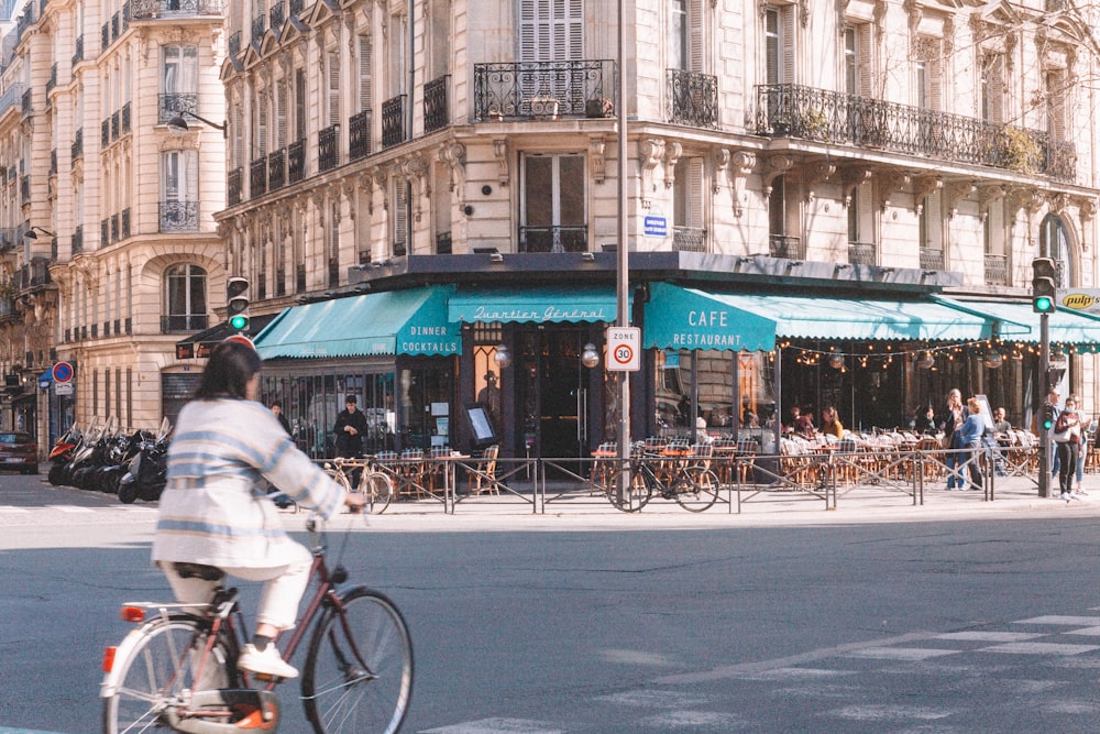 Un hombre montando en bicicleta por una calle junto a edificios altos