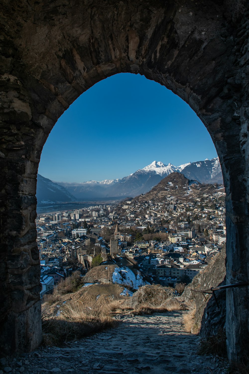 a view of a city through a stone arch