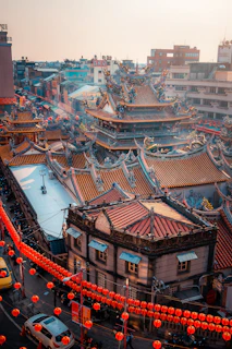 a city with a lot of red lanterns hanging from it's roof