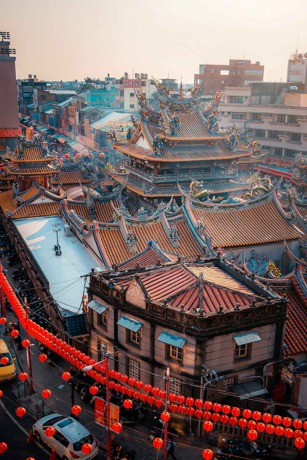 a city with a lot of red lanterns hanging from it's roof