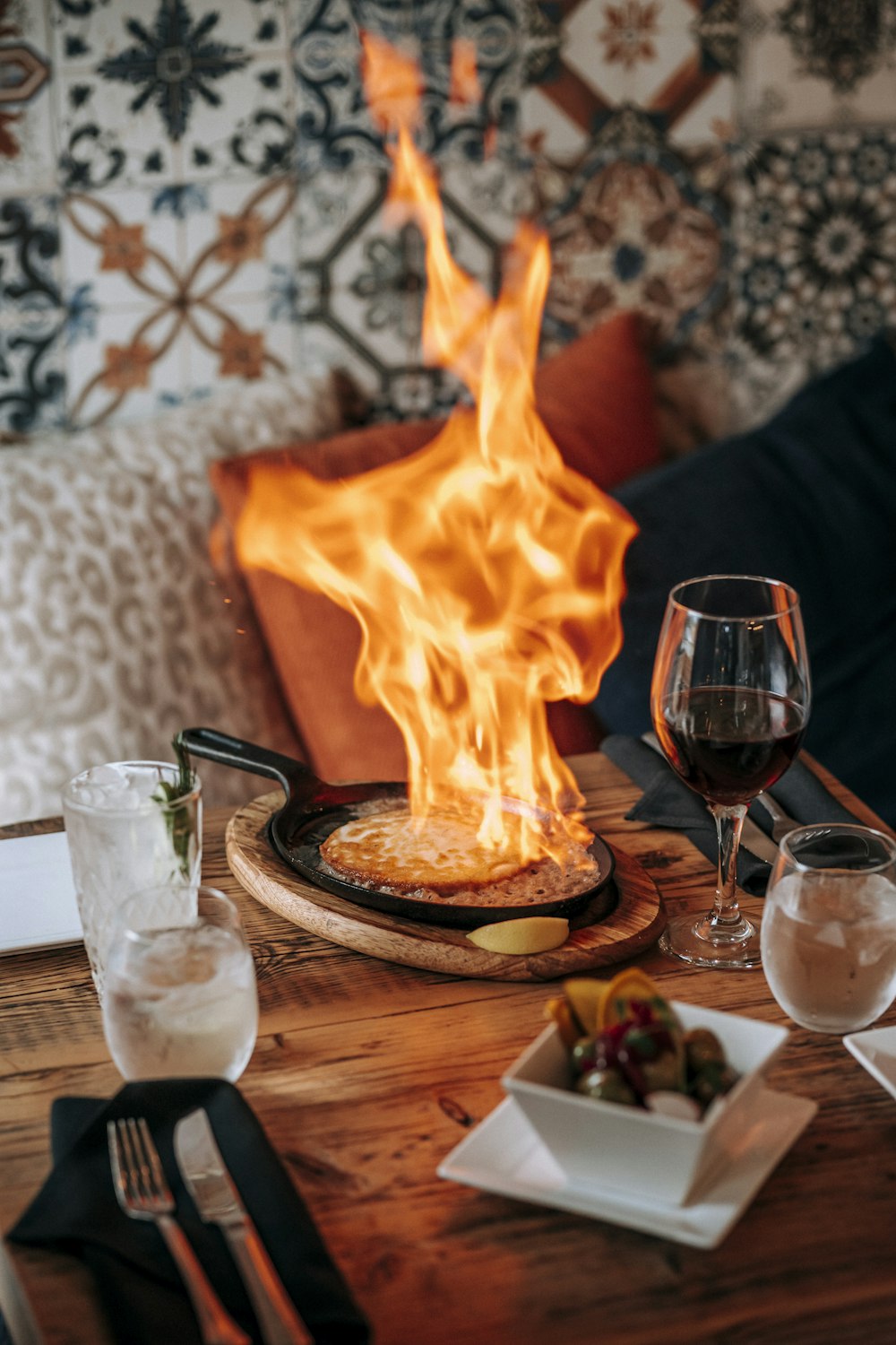 a table topped with a pizza covered in flames
