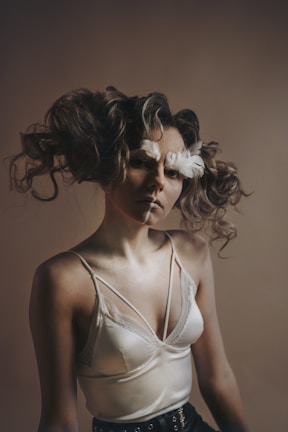 An alluring pose of a cam girl with soft shadows highlighting her curves.